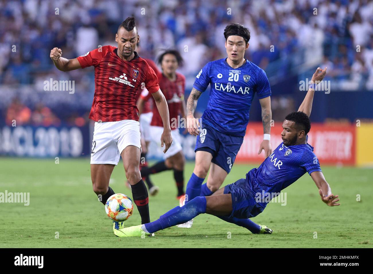 Al Hilal's Ali Al Bulayhi, right, fights for the ball with Urawa