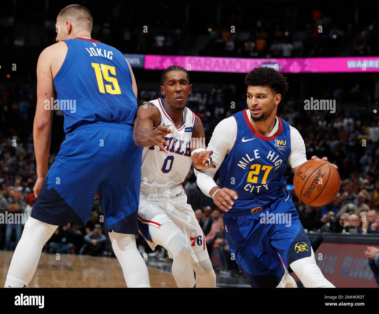 Philadelphia 76ers guard Josh Richardson, center, is hit as he tries to slip  past a pick set by Denver Nuggets center Nikola Jokic, left, as Nuggets  guard Jamal Murray drives to the