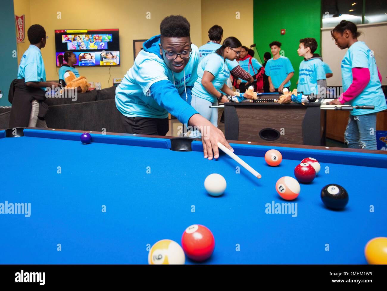 IMAGE DISTRIBUTED FOR AARON'S- William plays on a new pool table during the  unveiling of Aaron's $20,000 makeover of the teen center at Berkshire  Partners Blue Hill Boys and Girls Club of, image size:1300x978