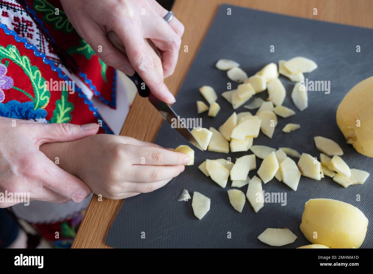 Mother and daughter together cut apples for a pie the concept of