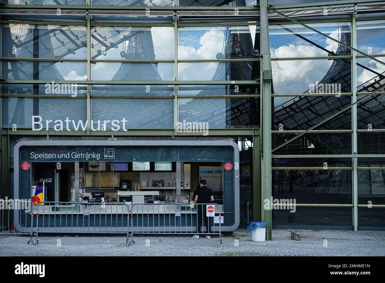 A man in front of a sausage stand at the Munich Olympic Stadium in Olympiapark. Stock Photo
