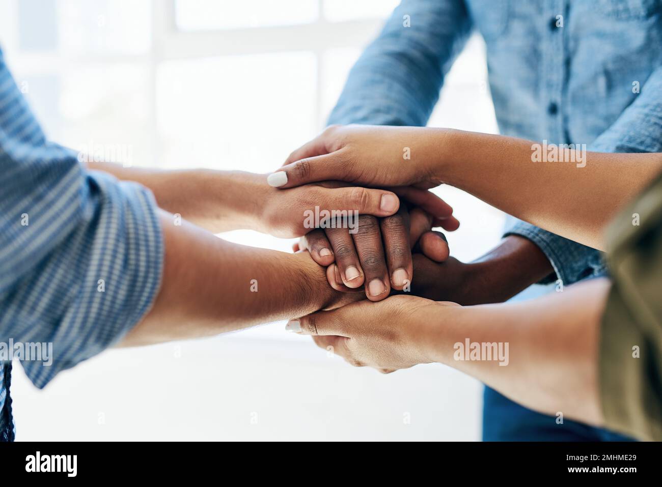 Working together as one unit. a work group joining hands in solidarity. Stock Photo