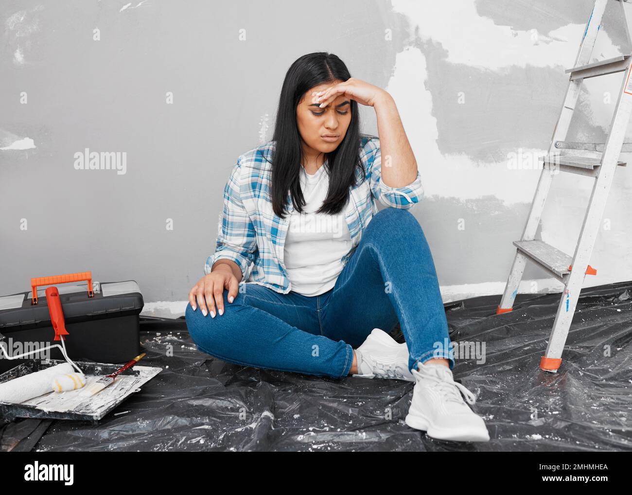 Young Indian woman frustrated, stuck with home DIY project Stock Photo