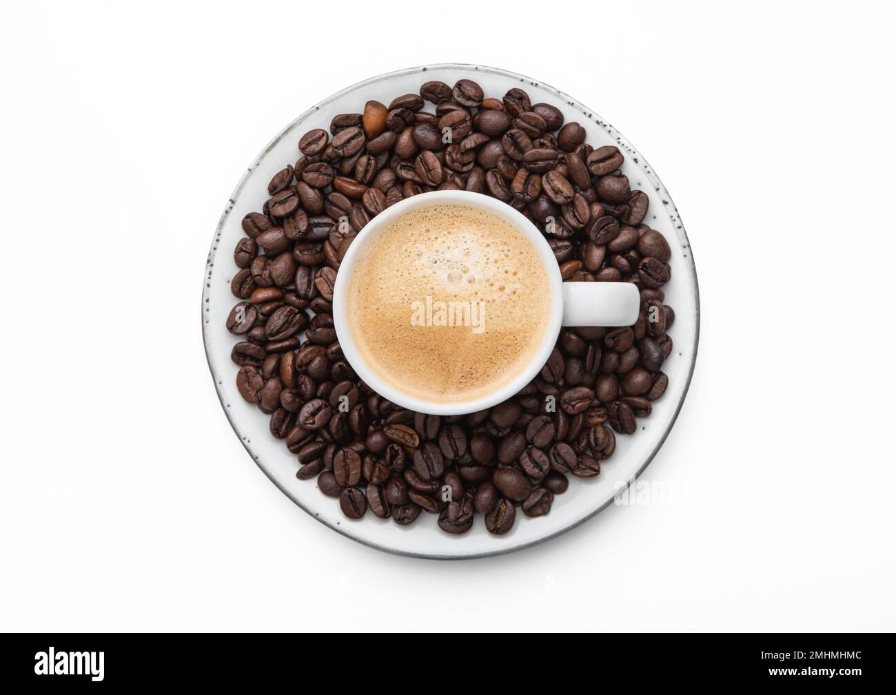 Espresso coffee in small cup and fresh raw beans on saucer on white