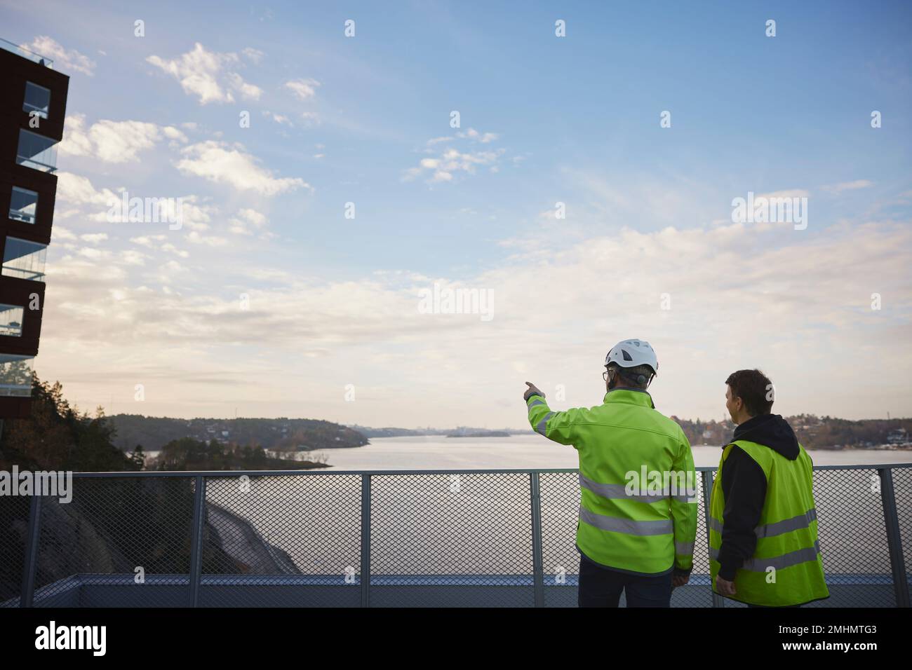 Engineers in reflective clothing talking outdoors Stock Photo