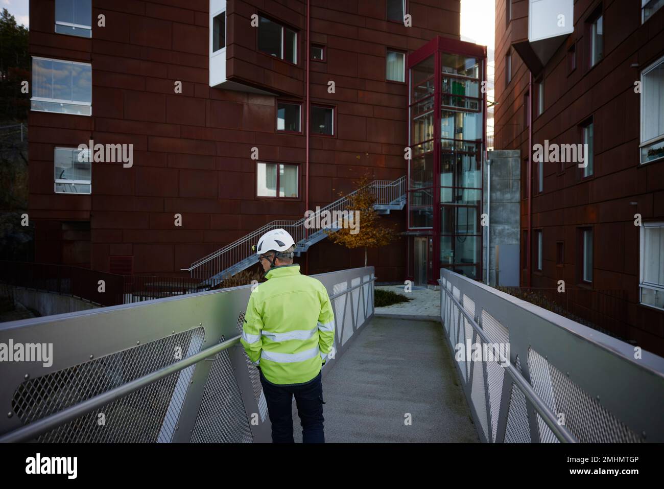Construction worker standing on bridge in residential area Stock Photo