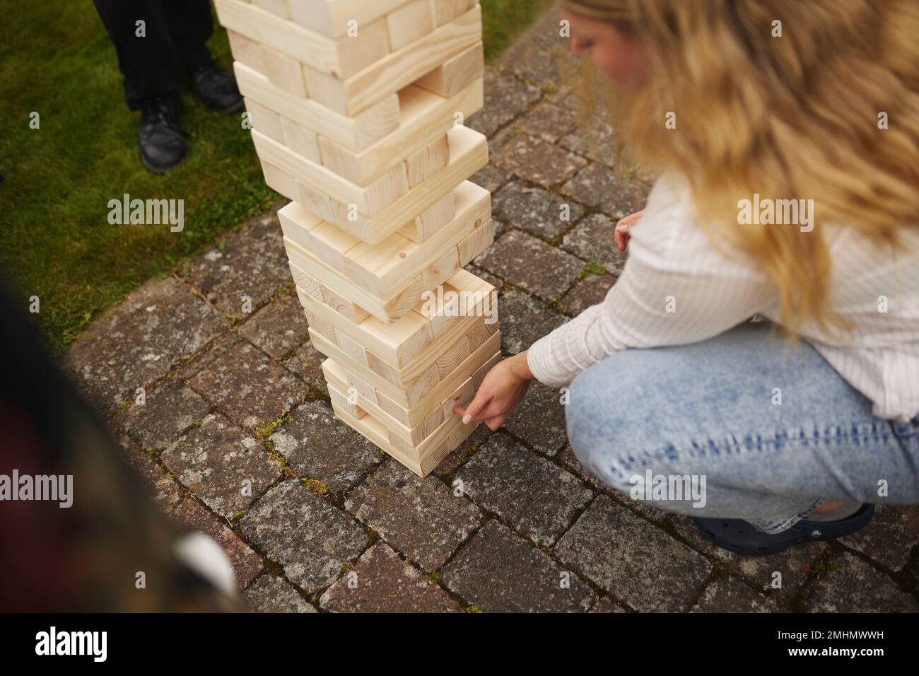Woman playing giant jenga Stock Photo