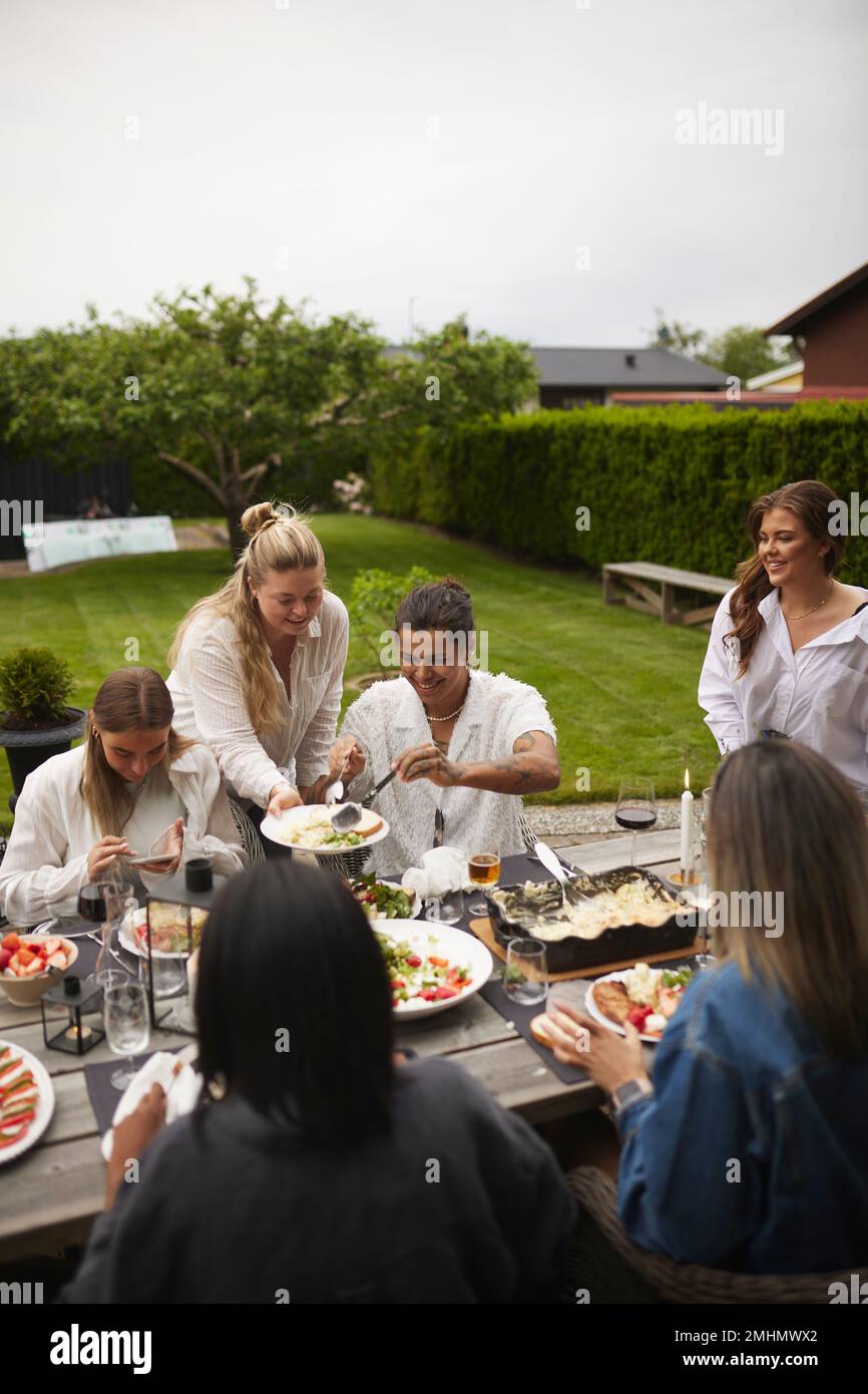 Friends having meal in garden Stock Photo