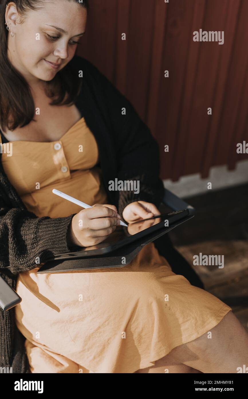 Smiling woman using digital tablet Stock Photo