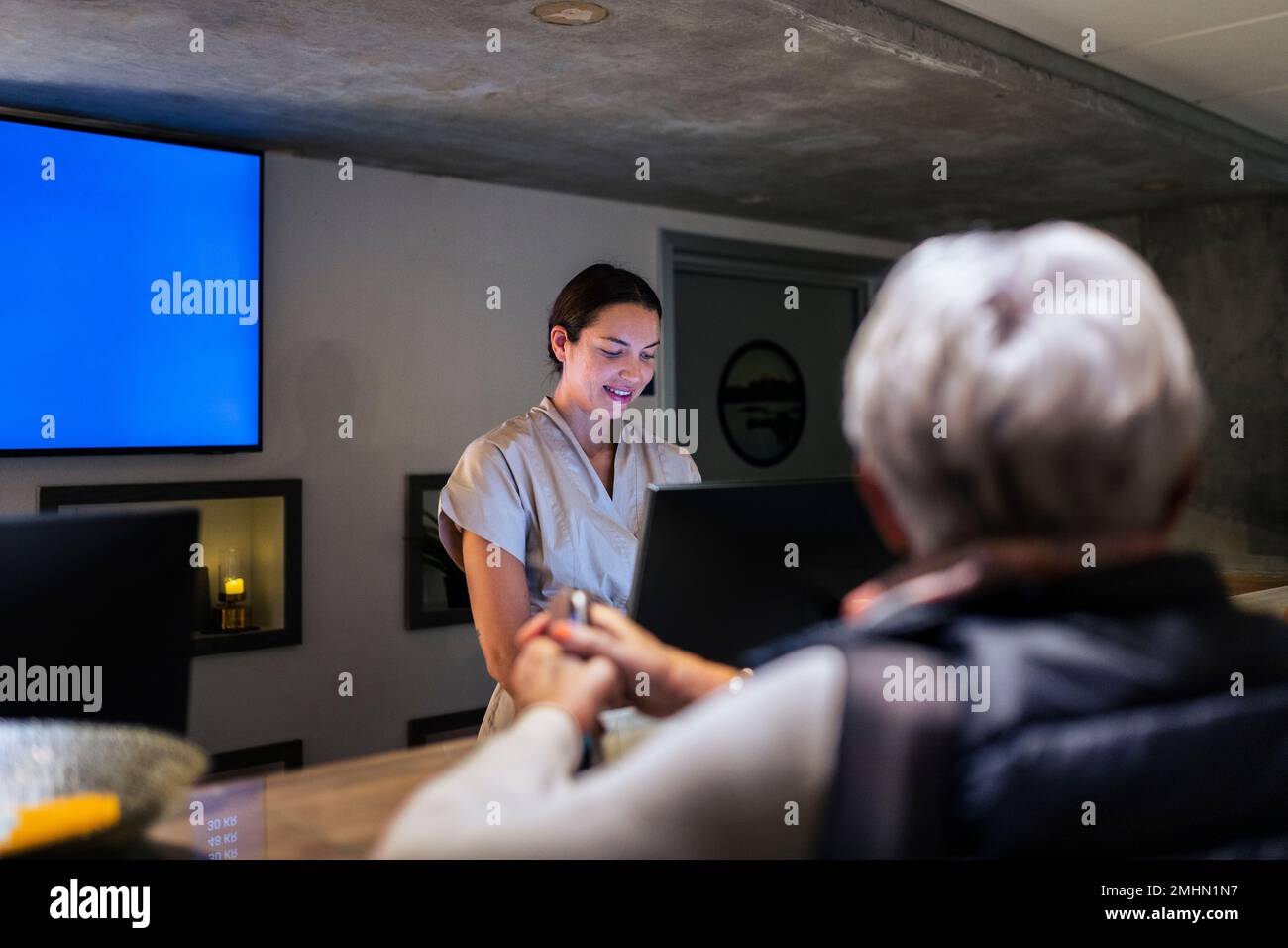 Receptionist assisting customer at health spa Stock Photo