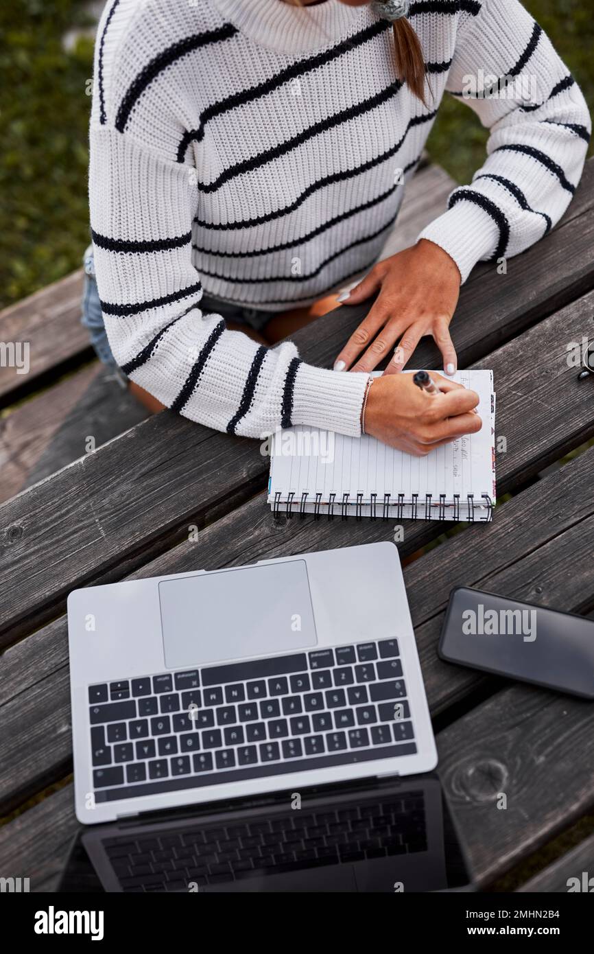 Mid section of woman writing in notepad Stock Photo