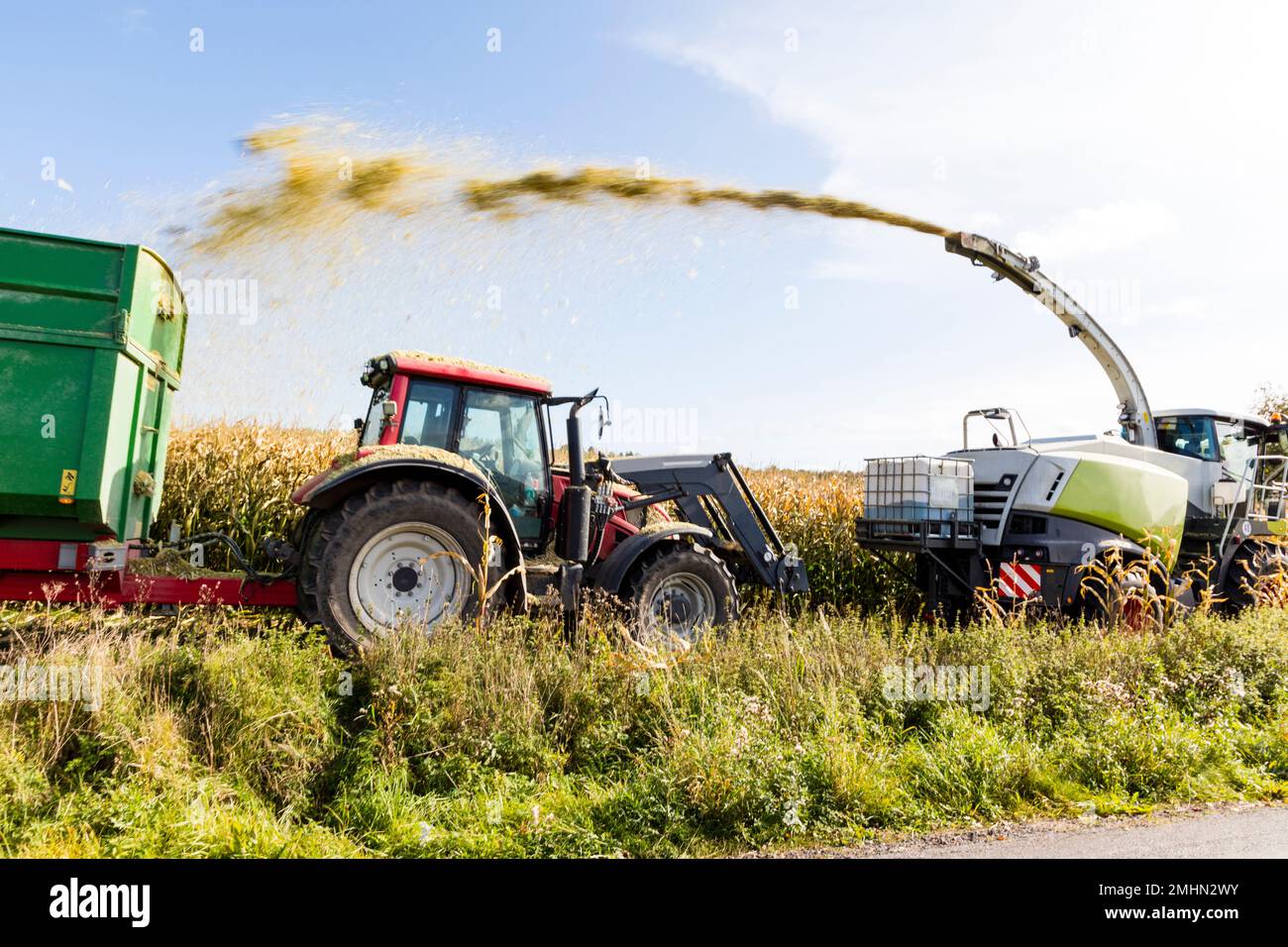 Combine and tractor harvesting corn Stock Photo Alamy