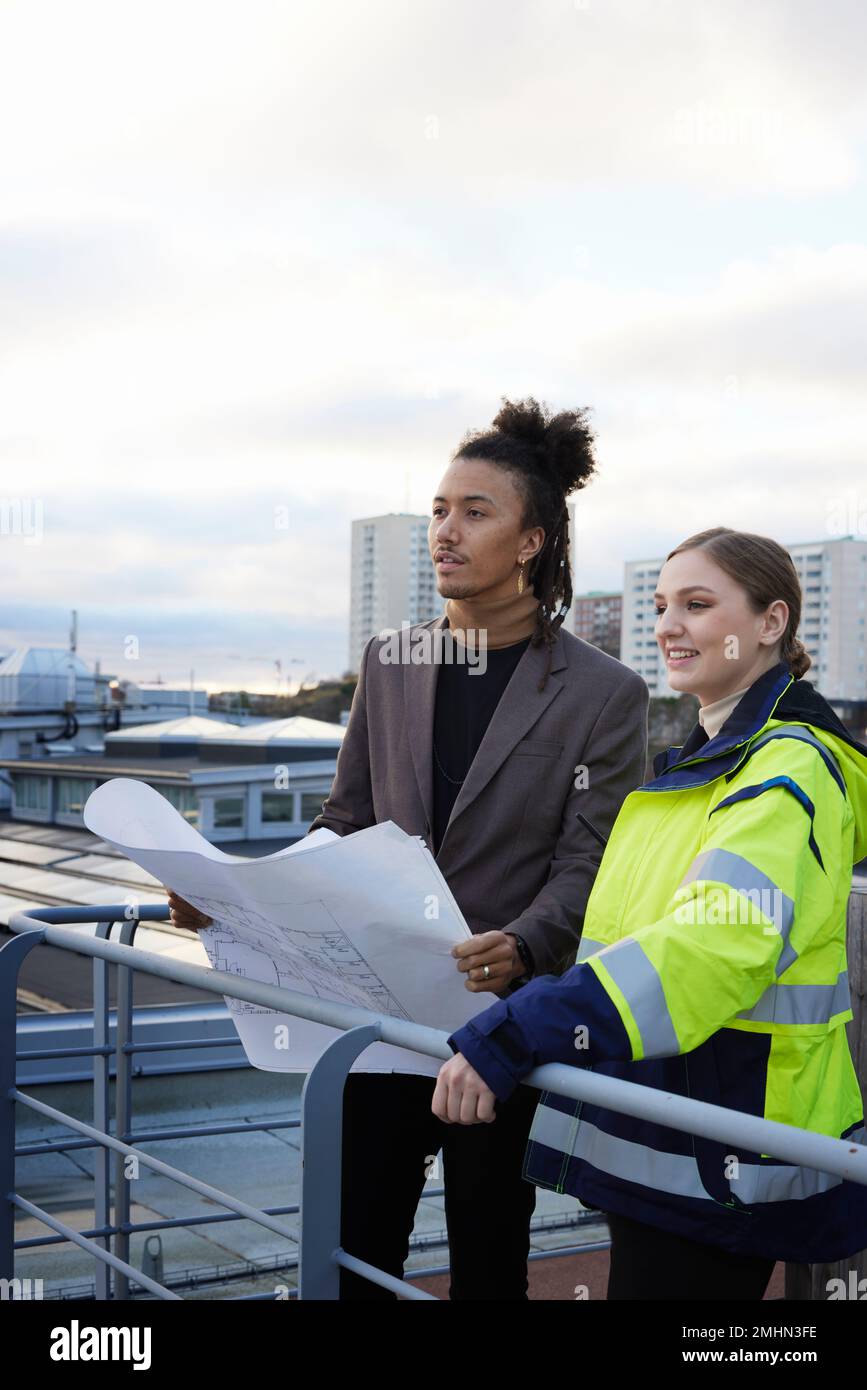 Architects talking while holding blueprints Stock Photo