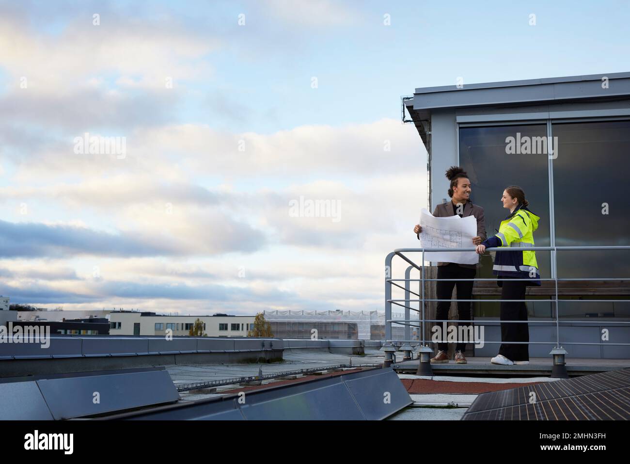 Architects talking while holding blueprints Stock Photo