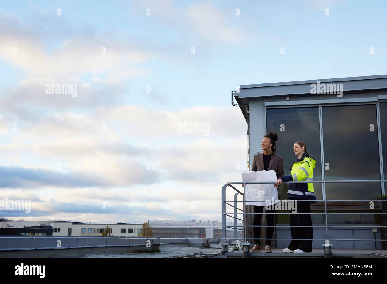 Architects talking while holding blueprints Stock Photo