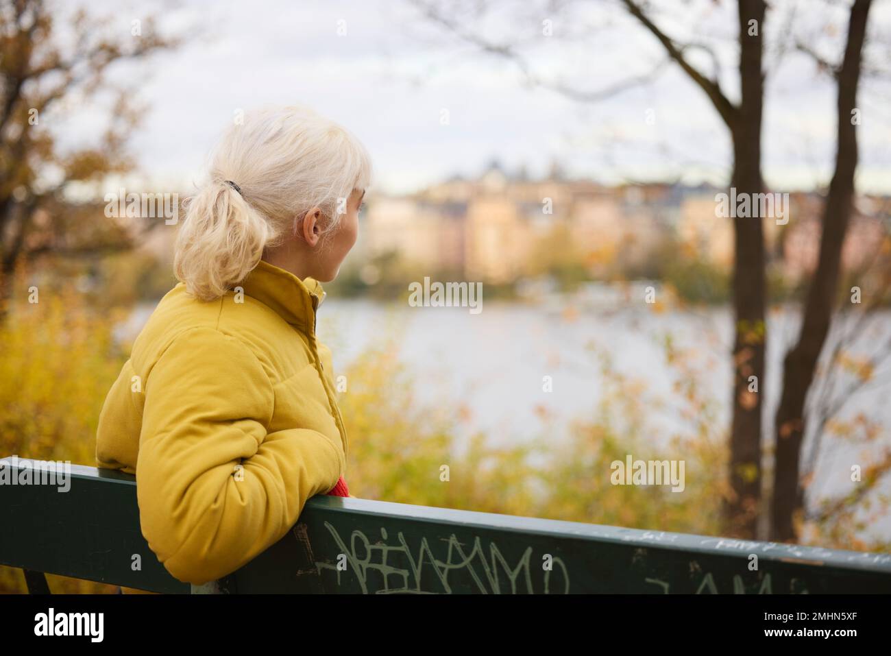 Young woman on bench looking away Stock Photo