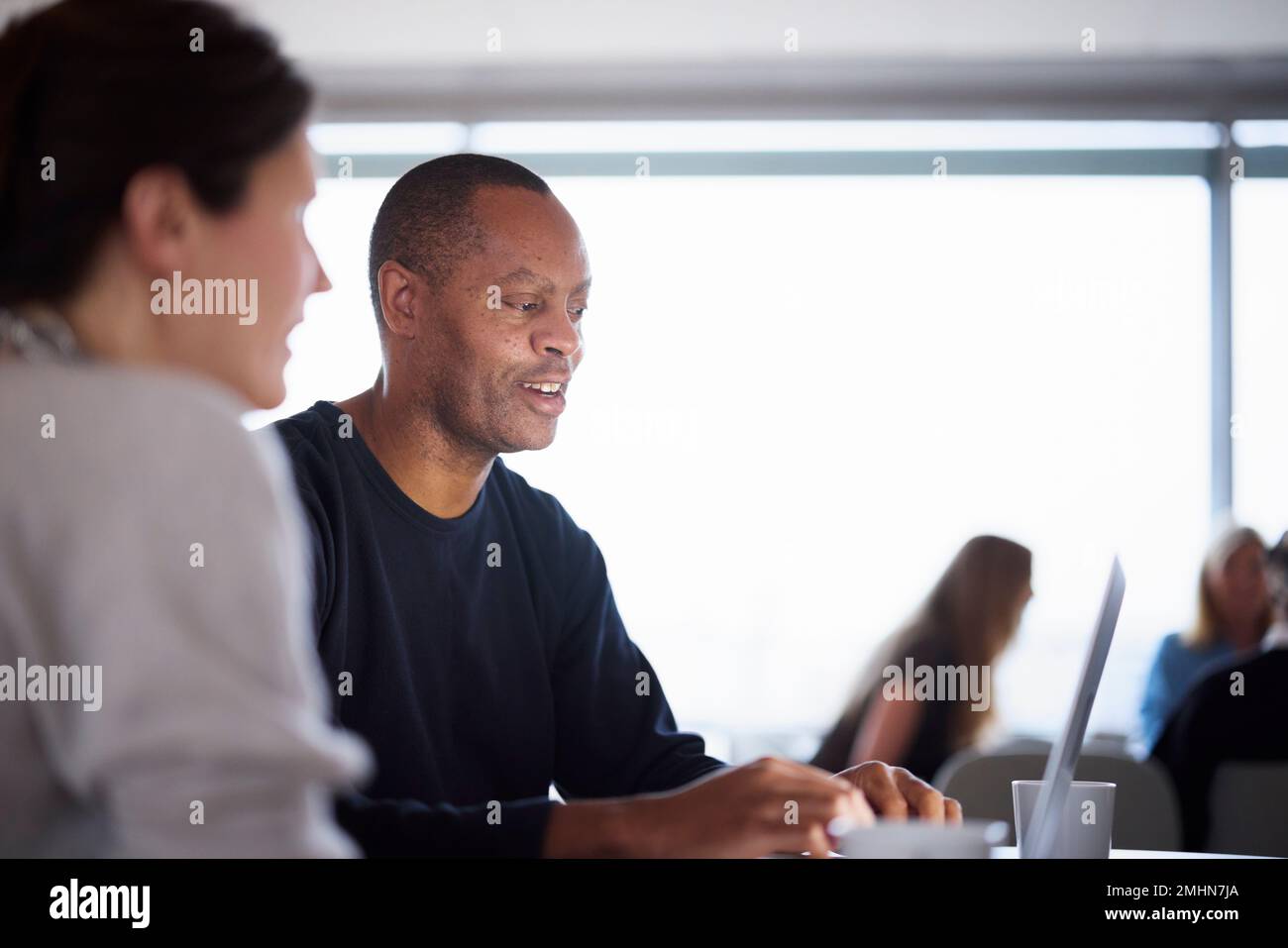 Smiling man talking in cafeteria Stock Photo