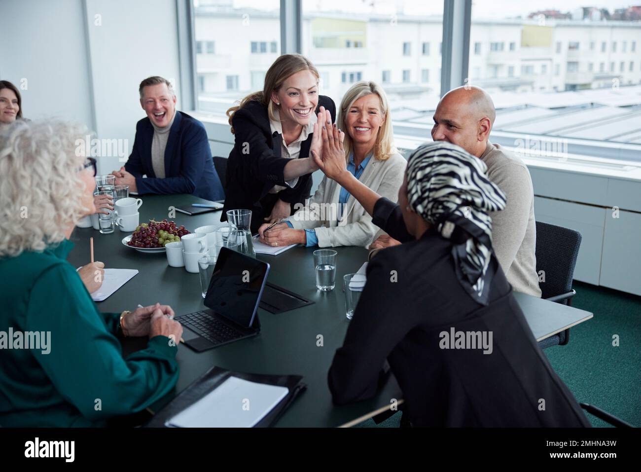 Women giving each other high five at business meeting Stock Photo - Alamy