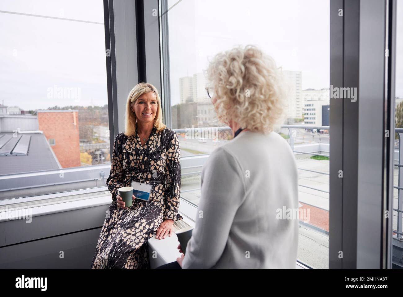 Businesswomen talking during coffee break in office Stock Photo