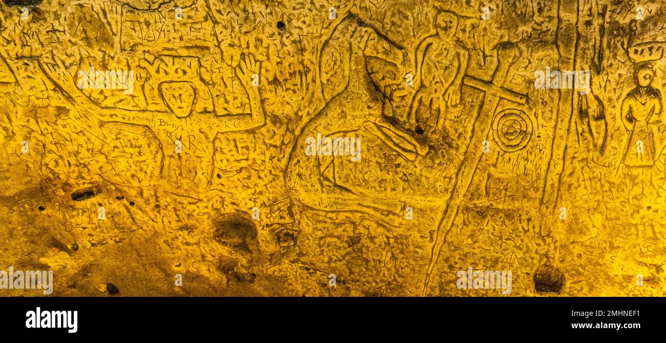 Royston Cave in Herfordshire U.K. still puzzles historians today. The figure on the far left of the picture with the raised arms could be King David from the Book of Psalms. Royston Cave in Katherine's Yard, Melbourn Street, Royston, England Stock Photo