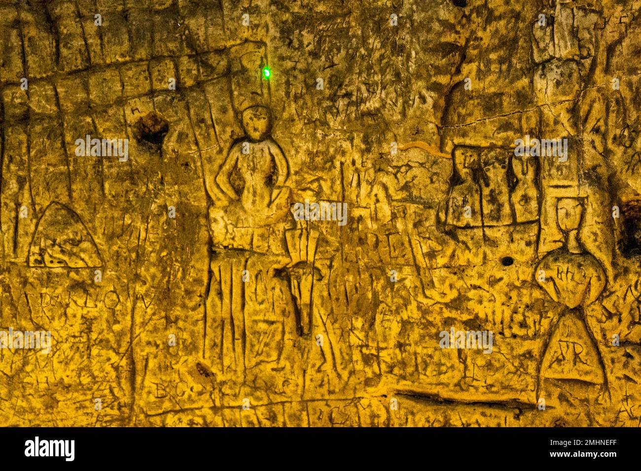 A laser pointer is used to explain the mysterious carvings in Royston Cave to groups of visitors. Royston Cave in Katherine's Yard, Melbourn Street, Royston, England Stock Photo
