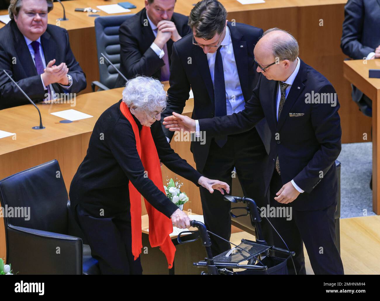 Duesseldorf, Germany. 27th Jan, 2023. Hendrik Wüst (M, CDU), Minister President of North Rhine-Westphalia, Andre Super (r, CDU), President of the State Parliament, help Ruth Weiss (l), journalist and writer, on her way to the lectern during a memorial hour for the victims of National Socialism in the State Parliament of North Rhine-Westphalia. The internationally observed Holocaust Memorial Day on January 27 commemorates the liberation of the German death camp Auschwitz in 1945. Credit: Oliver Berg/dpa/Alamy Live News Stock Photo