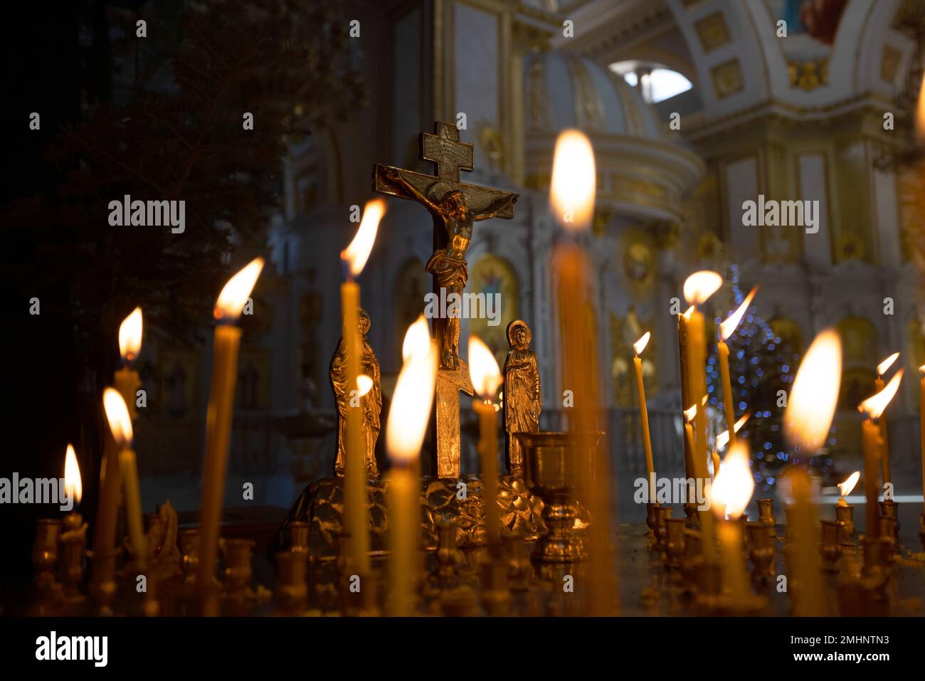 Сoncept of Christian religion. Сross with crucifix in focus, lit wax