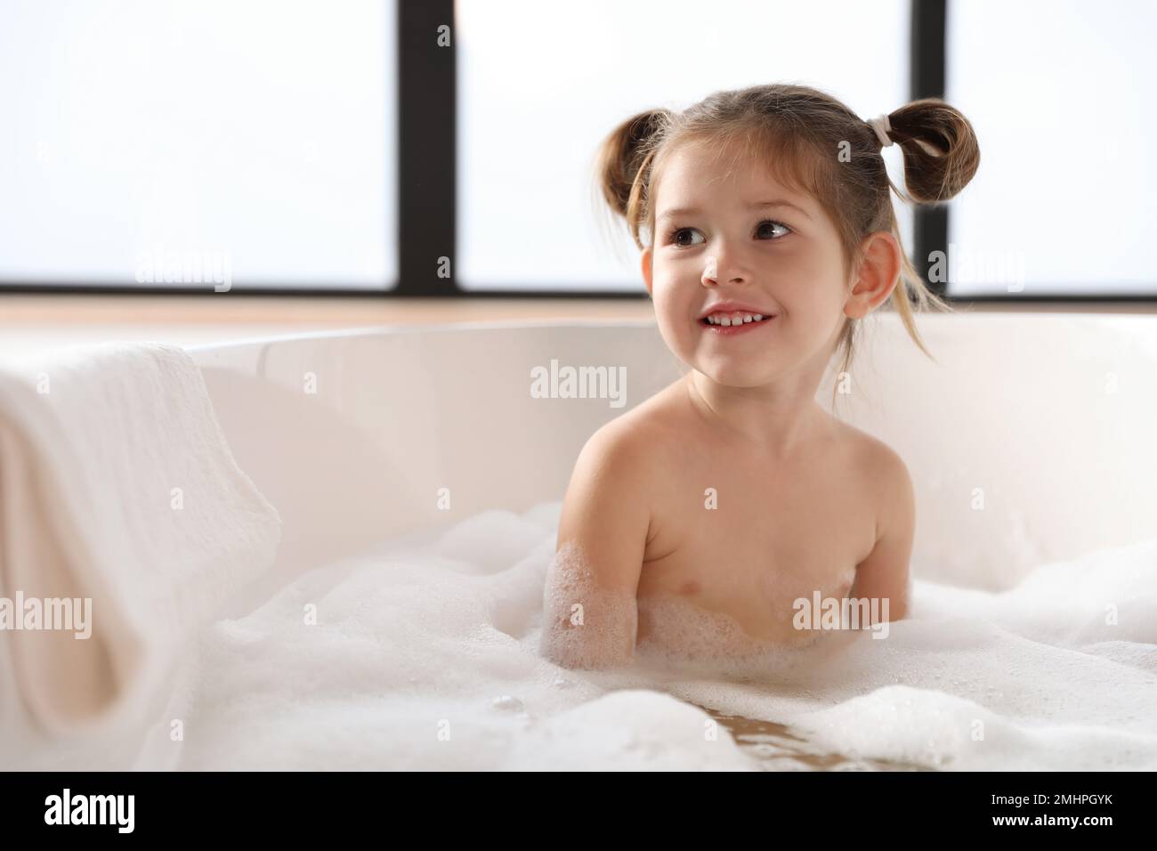 Cute little girl taking bubble bath at home Stock Photo - Alamy