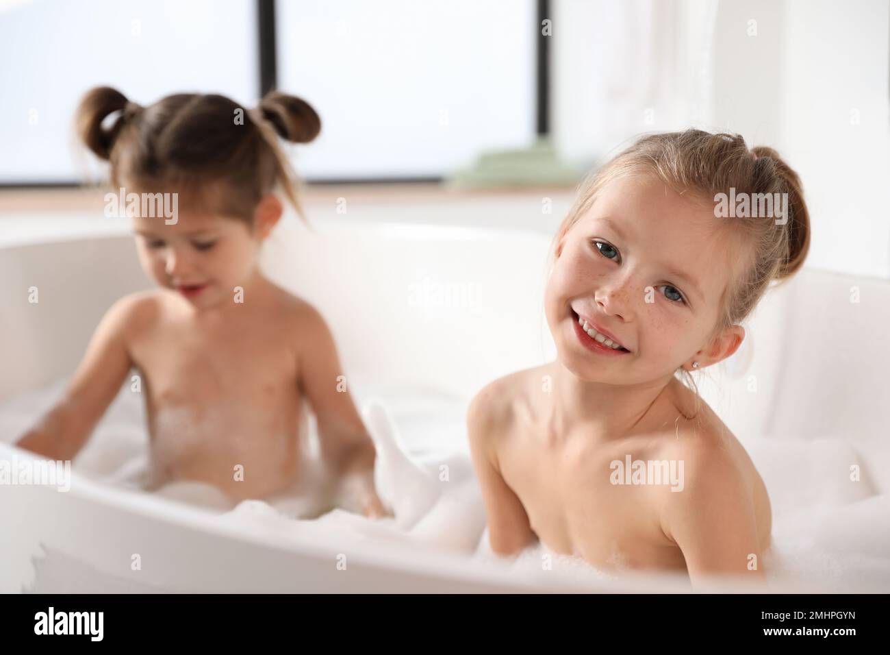 Cute little sisters taking bubble bath together Stock Photo Alamy