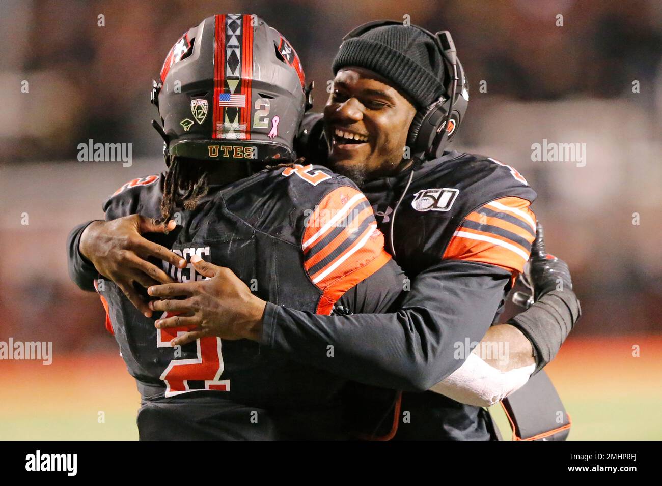 Utah's Tyler Huntley, right, hugs Zack Moss (2) after his 10-yard