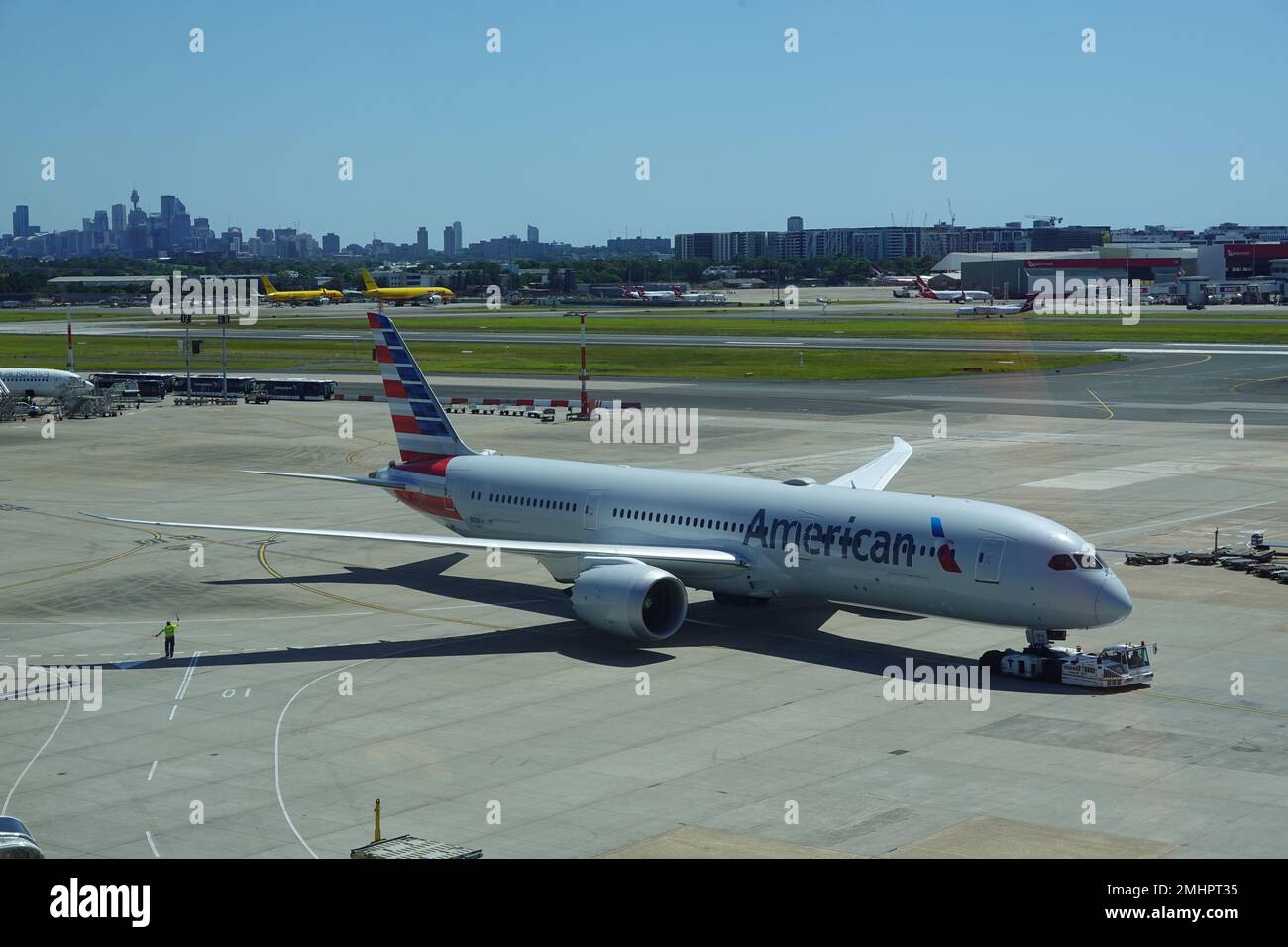 January 2023, American Airways plane at Sydney Kingsford Smith airport with Sydney city skyline in the distance. Stock Photo