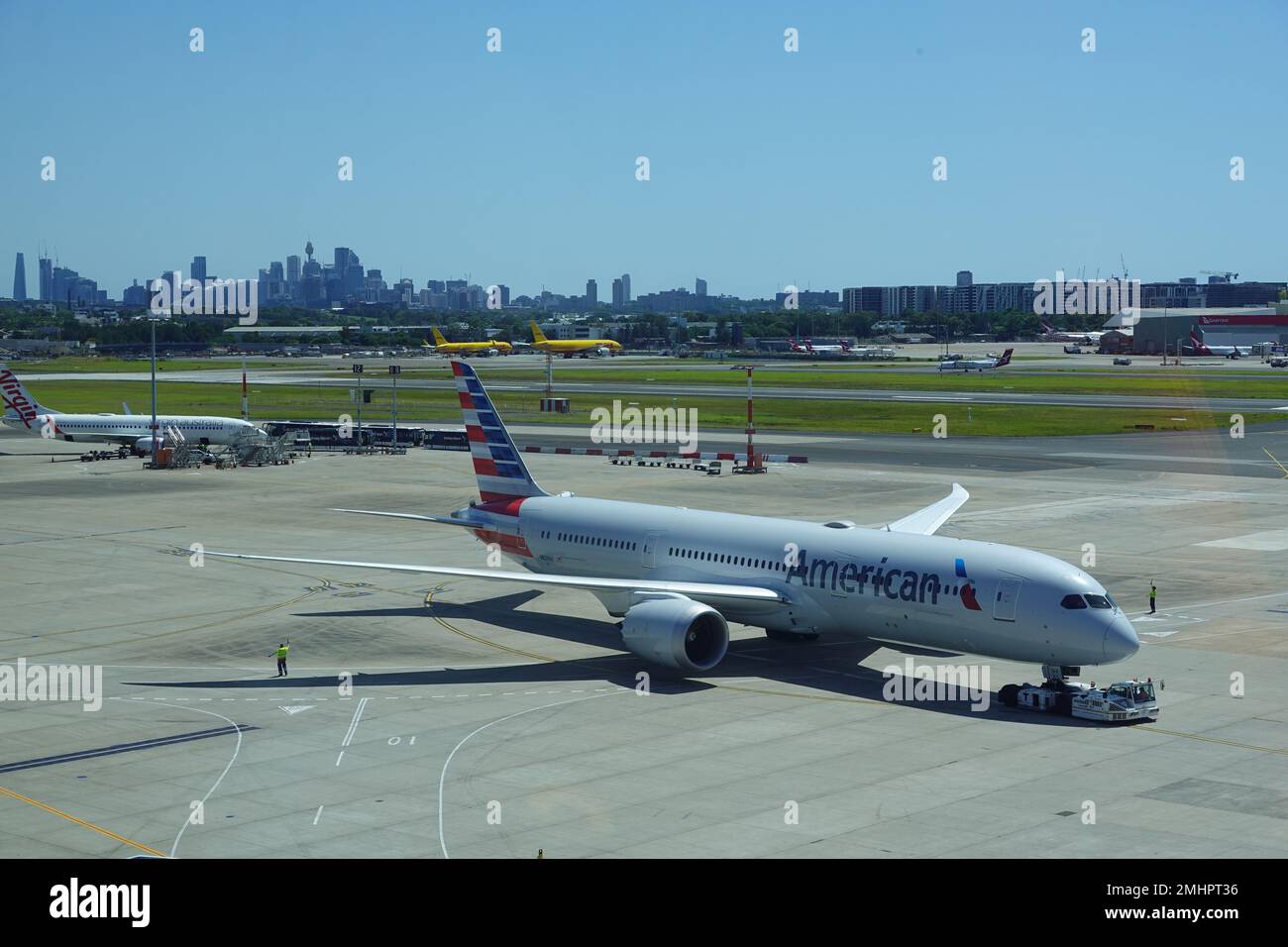 January 2023, American Airways plane at Sydney Kingsford Smith airport with Sydney city skyline in the distance. Stock Photo