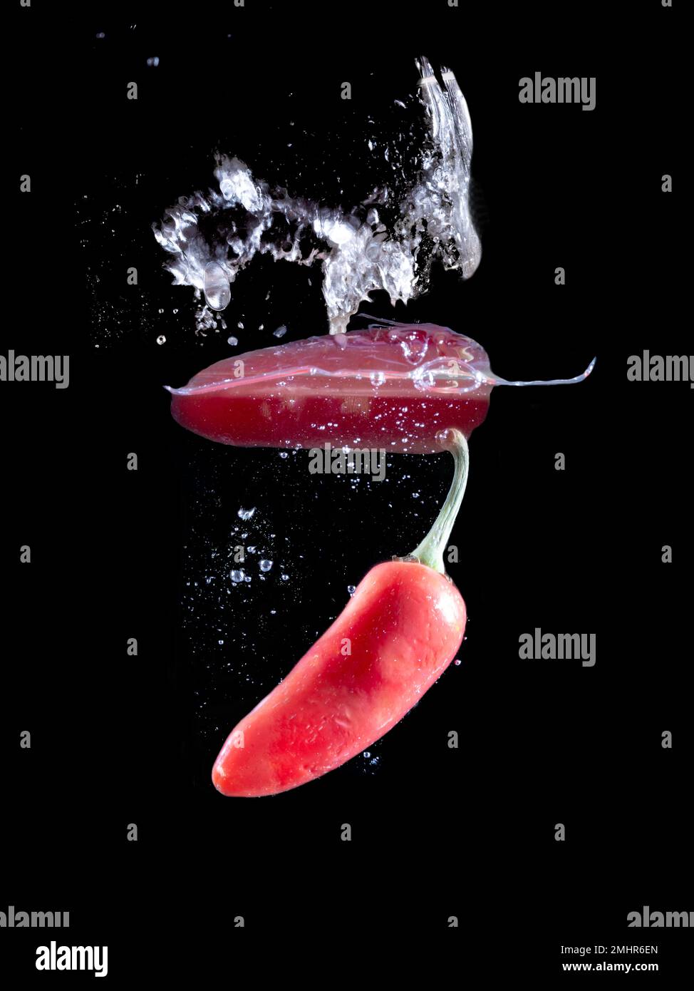 Red hot peppers in water splash over black background Stock Photo Alamy