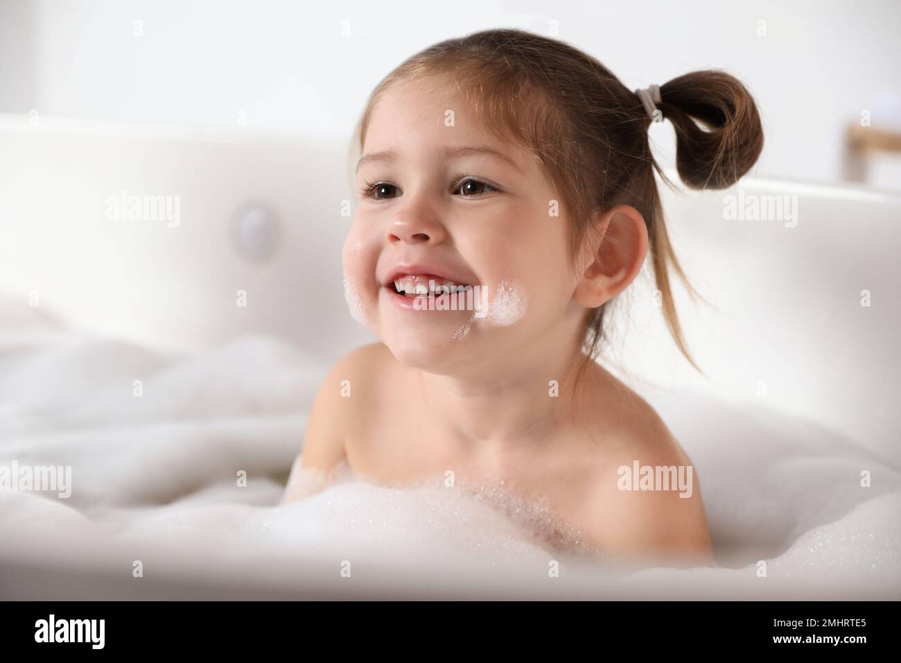 Cute little girl taking bubble bath at home Stock Photo Alamy