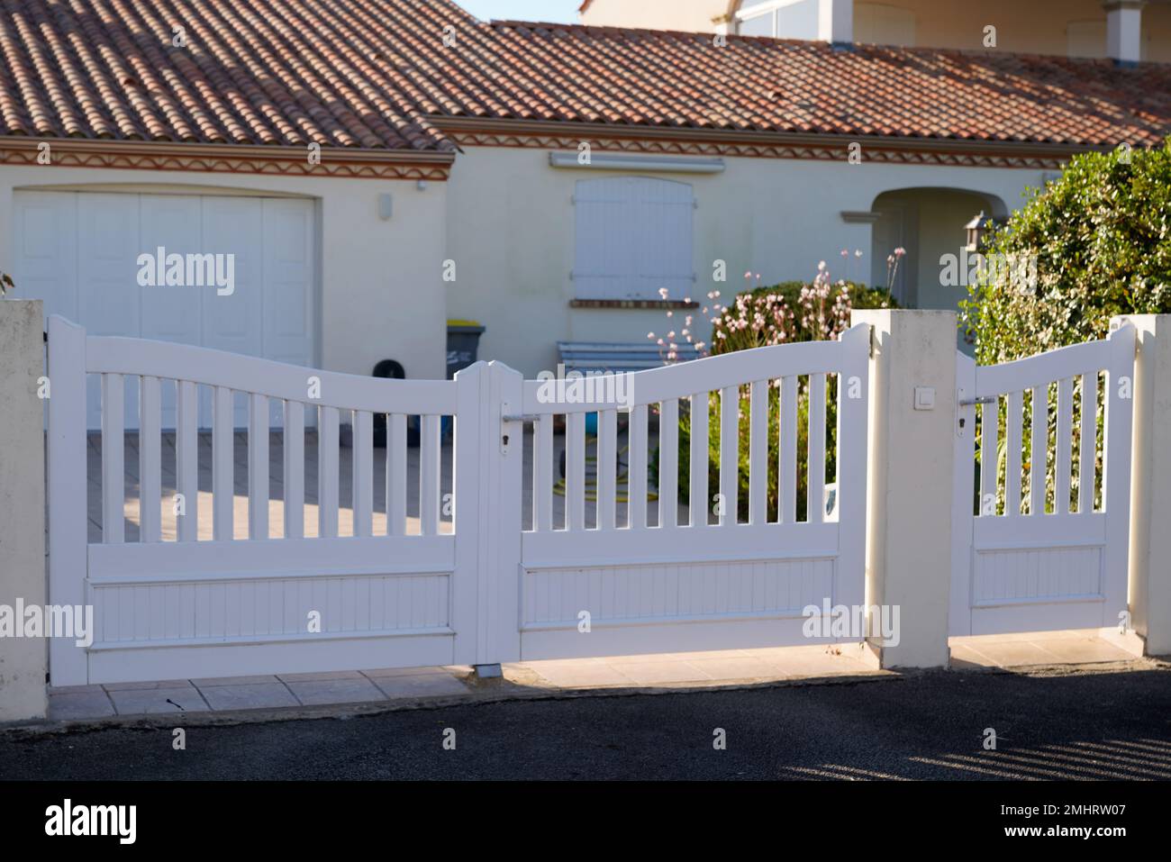 suburban pvc plastic gate white fence on home suburb street access house garden Stock Photo