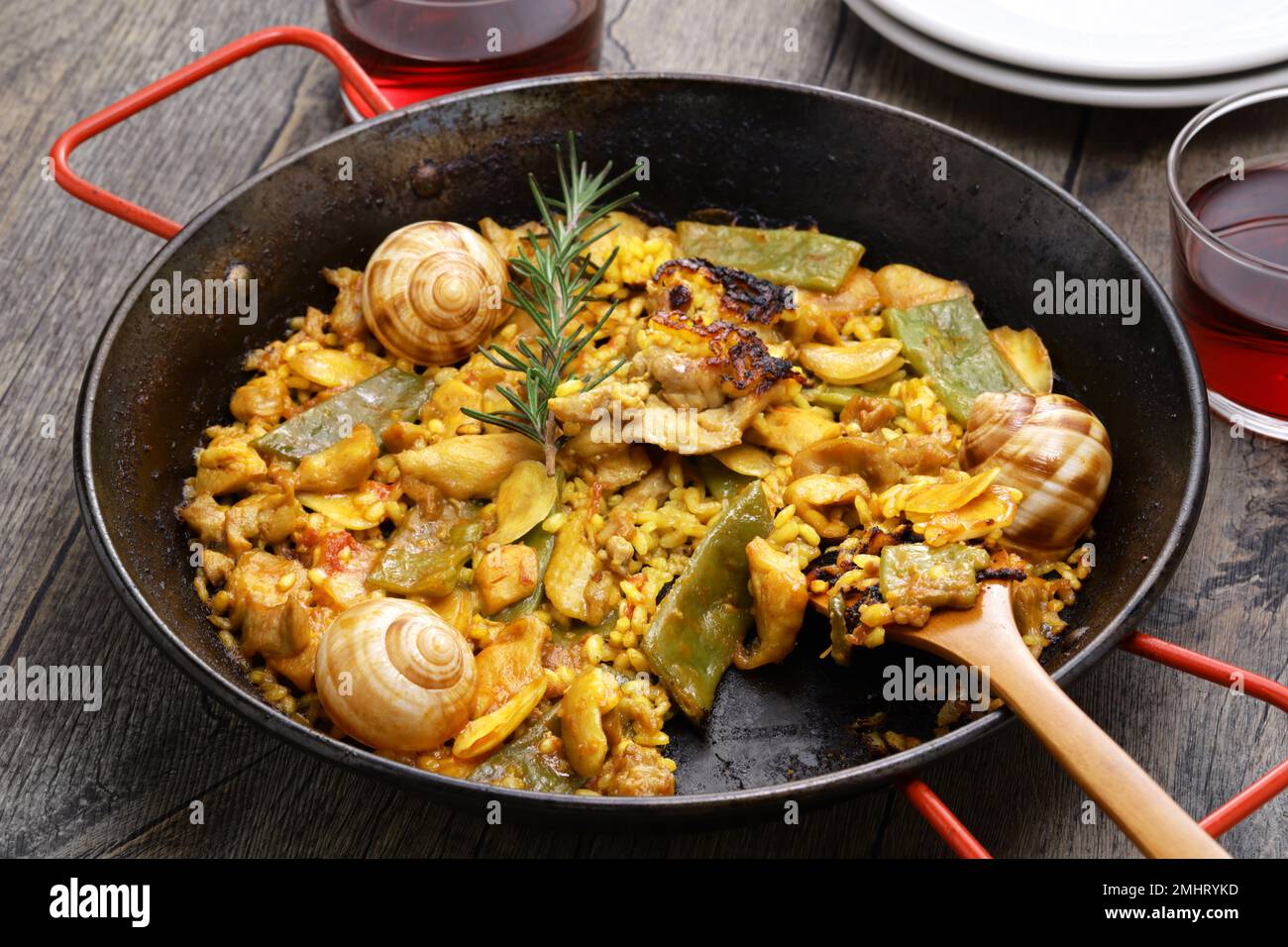 Paella Valenciana (Spanish traditional rice dish); rabbit, chicken, garrofon beans, snails, Moroccan green beans, saffron, and bomba rice. Stock Photo