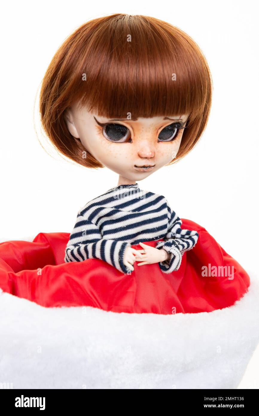 Portrait doll in a red and white christmas cap Stock Photo