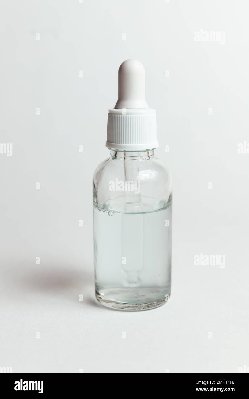 Glass dropper bottle with white cap for cosmetics on white background. Mock up, shadow Stock Photo