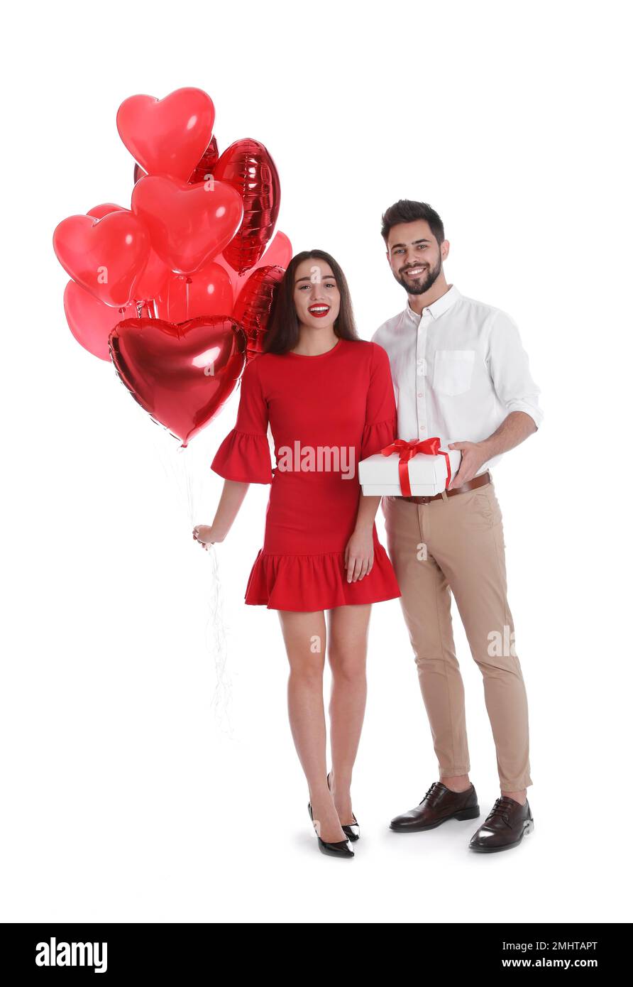 Happy young couple with gift box and heart shaped balloons isolated on ...