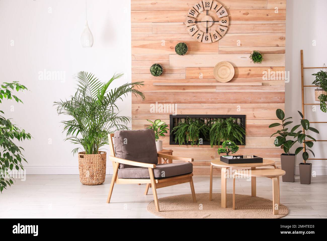 Stylish living room interior with armchair, green plants and miniature