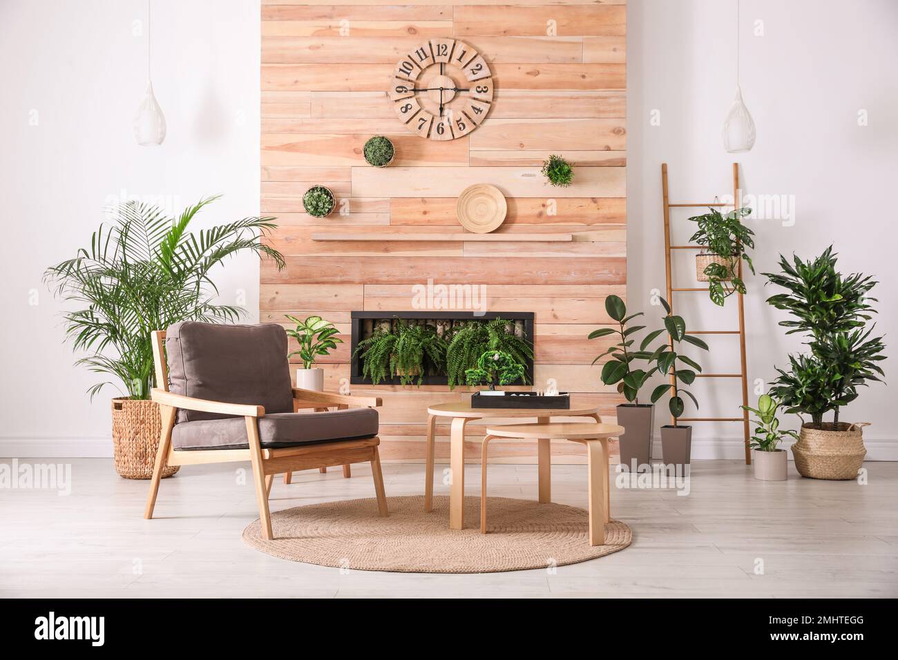 Stylish living room interior with armchair, green plants and miniature