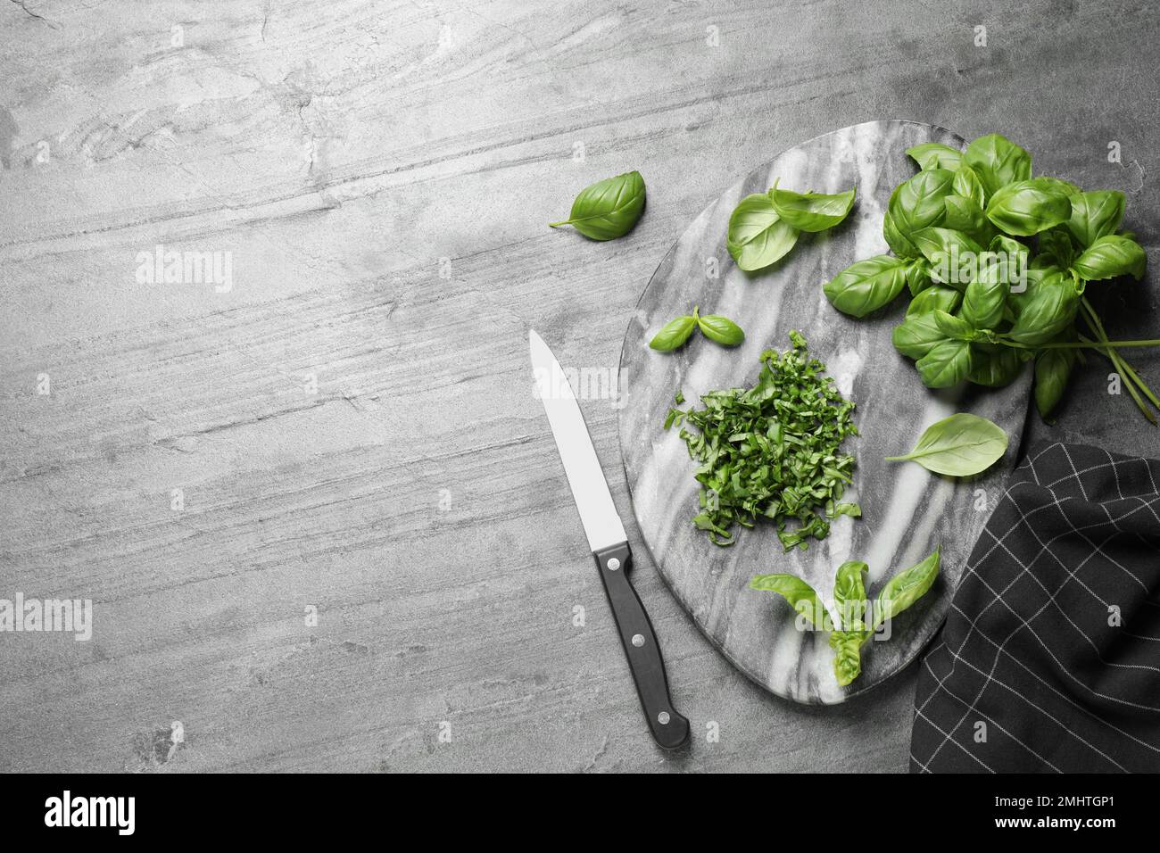 Flat lay composition with fresh basil on light grey table, space for ...