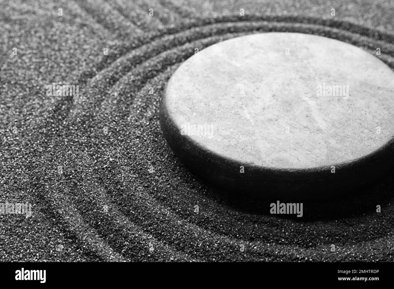 Zen garden stone on black sand with pattern, closeup Stock Photo Alamy