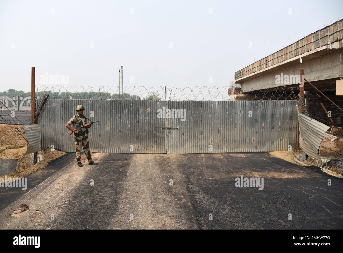 An Indian Border Security Force (BSF) soldier stands guard at a newly built road for Indian Sikh