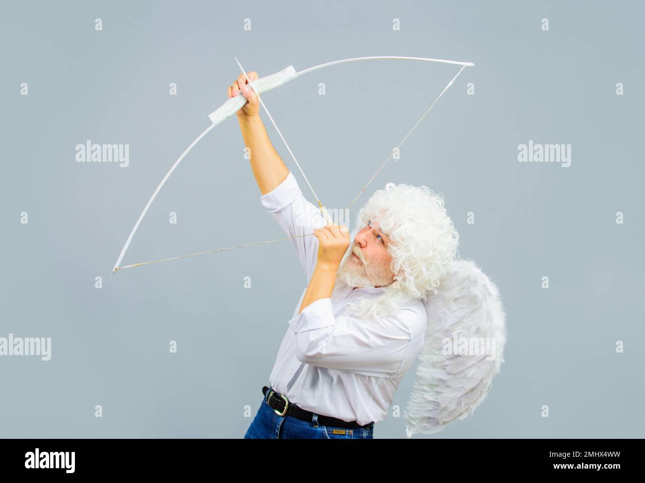 Male angel aiming up with bow and arrow. February 14. Saint Valentines Day. Arrows of love. Cupid. Stock Photo
