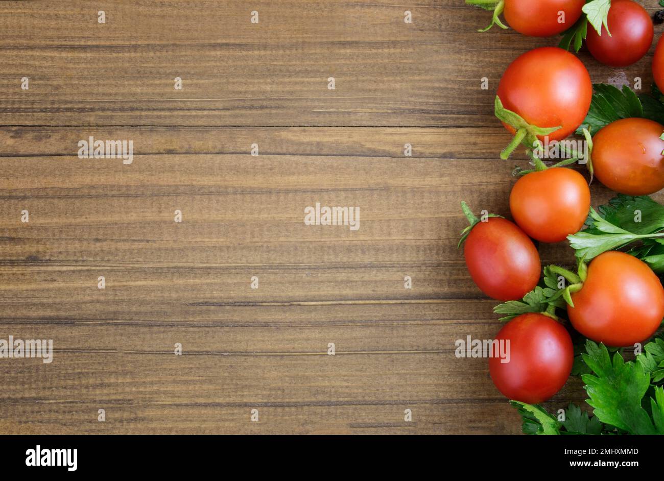 Cherry tomatoes on a wooden background. The concept of recipes with tomatoes, canning. Border. Copy space Stock Photo