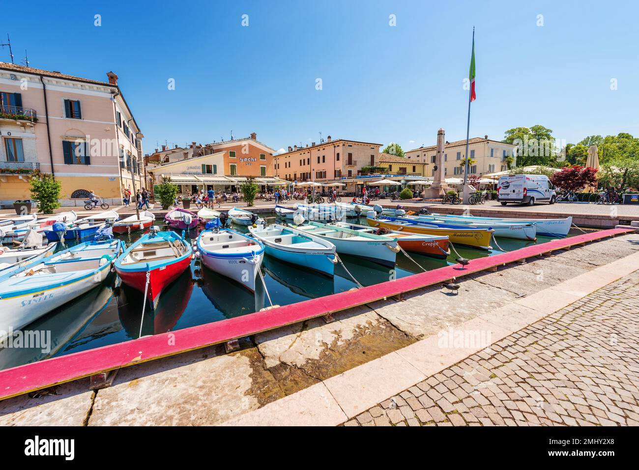 Port of the village of Bardolino with many boats moored. Tourist resort on the coast of Lake Garda (Lago di Garda). Verona, Veneto, Italy, Europe. Stock Photo