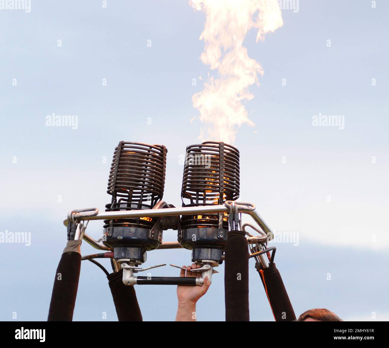 Pilot hand regulating gas burner preparing balloon for flight, fire