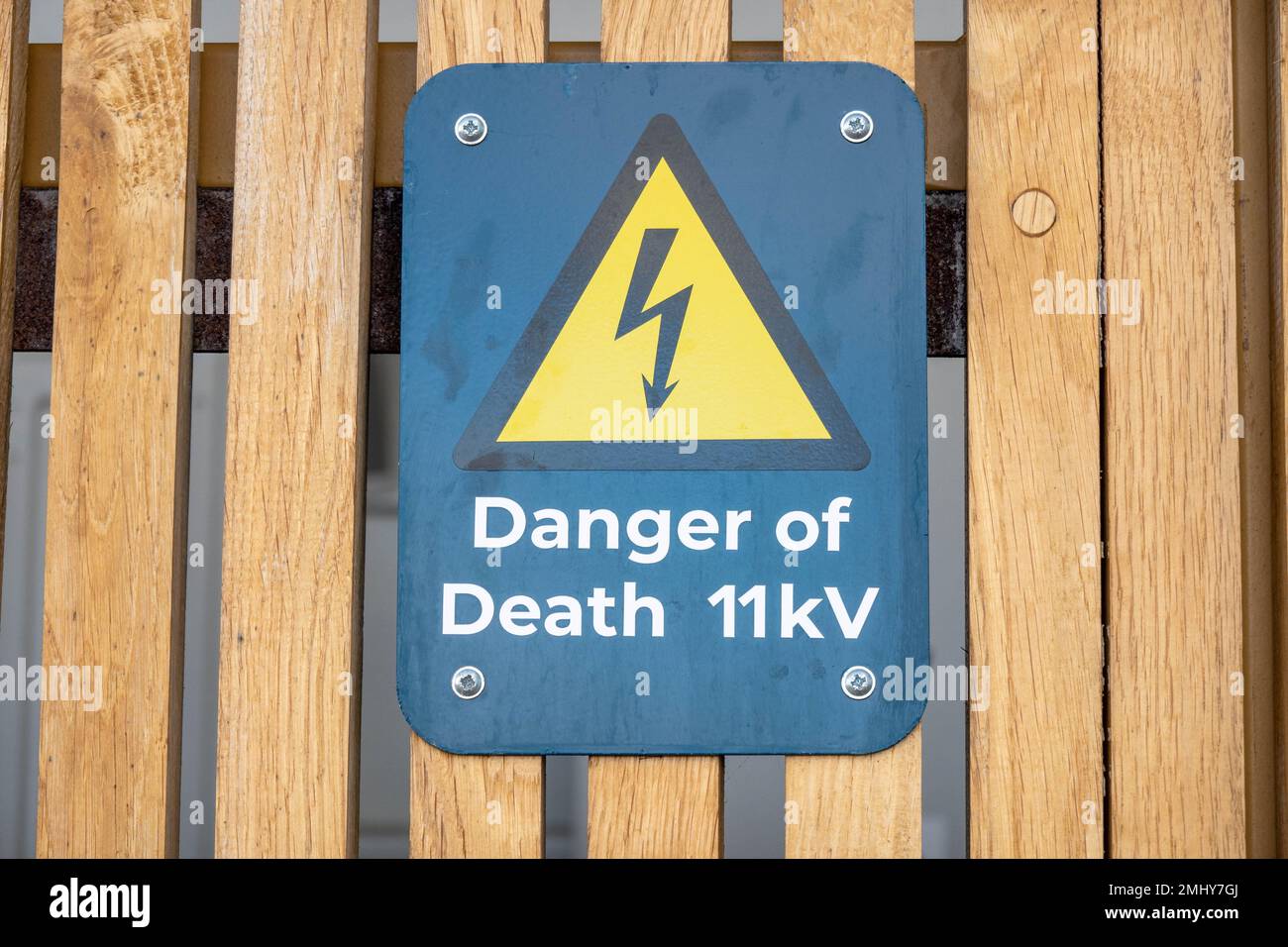 Electrical 11kV danger of death sign on a wooden fence panel Stock Photo