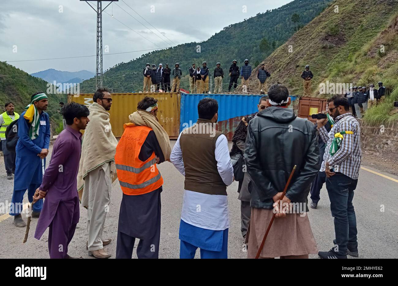 Police officers standing on top of shipping containers block the jammu